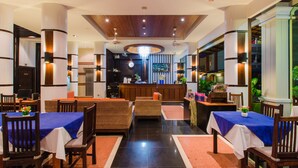 A modern hotel lobby with a reception desk, seating area, and a view of the kitchen. - Azure Bangla Phuket (Patong)