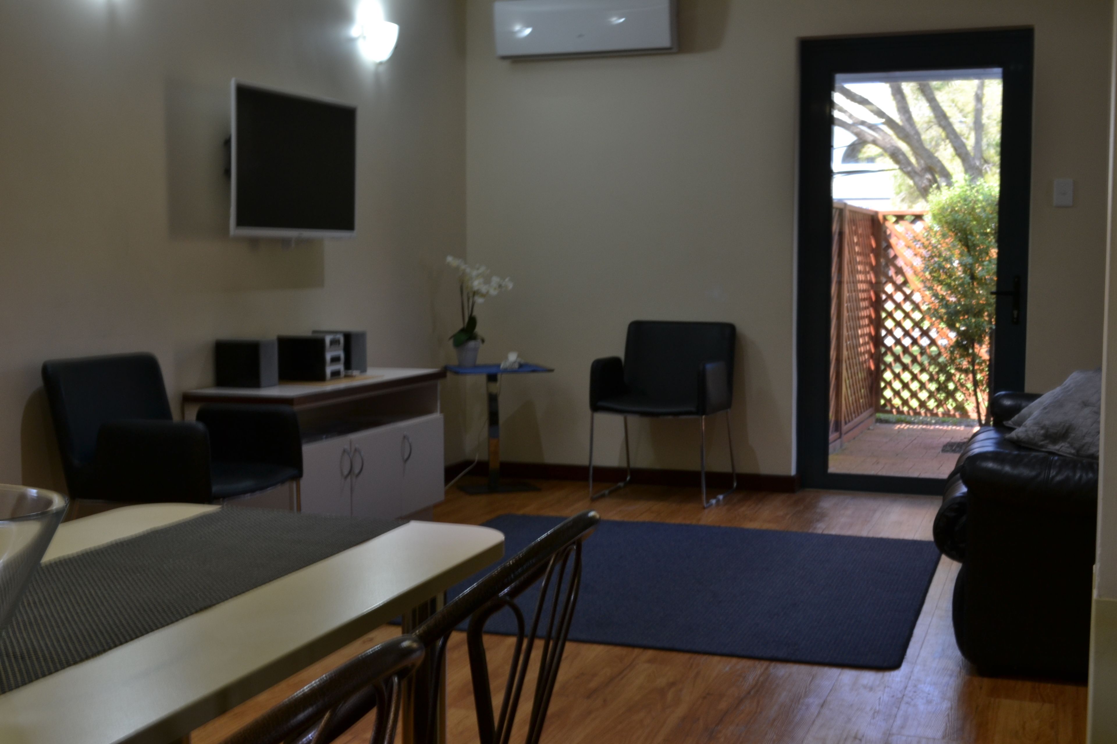 A compact living space with a kitchenette, a dining area, and a seating area with a sofa and chairs.
