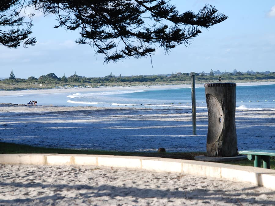 Beach nearby, white sand, beach towels, windsurfing