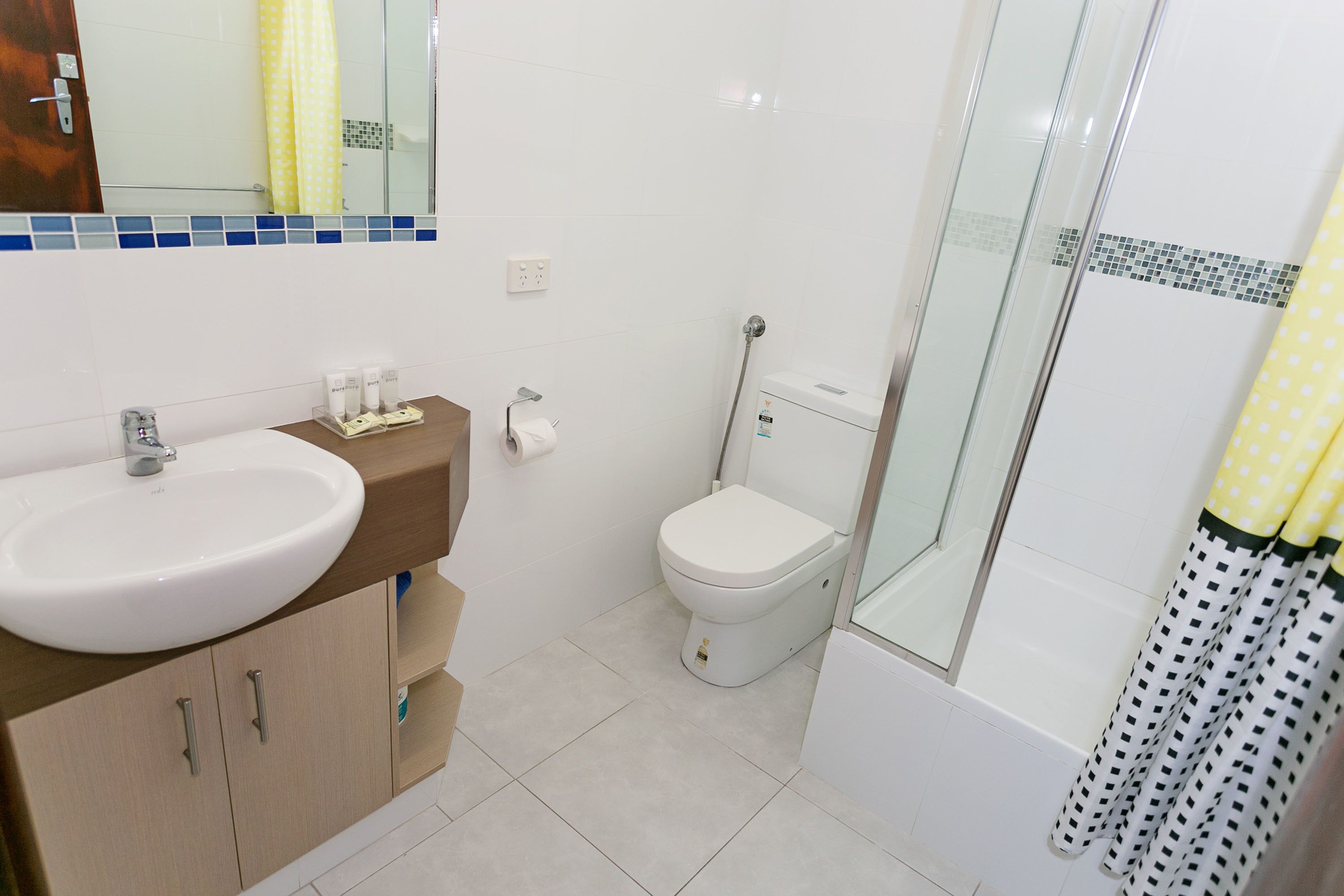 A bathroom with a sink, toilet, and shower area.