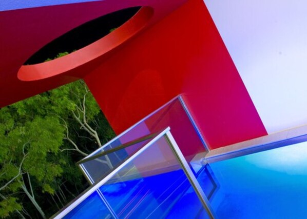 Una estructura arquitectónica moderna con un balcón de vidrio y una fachada colorida.