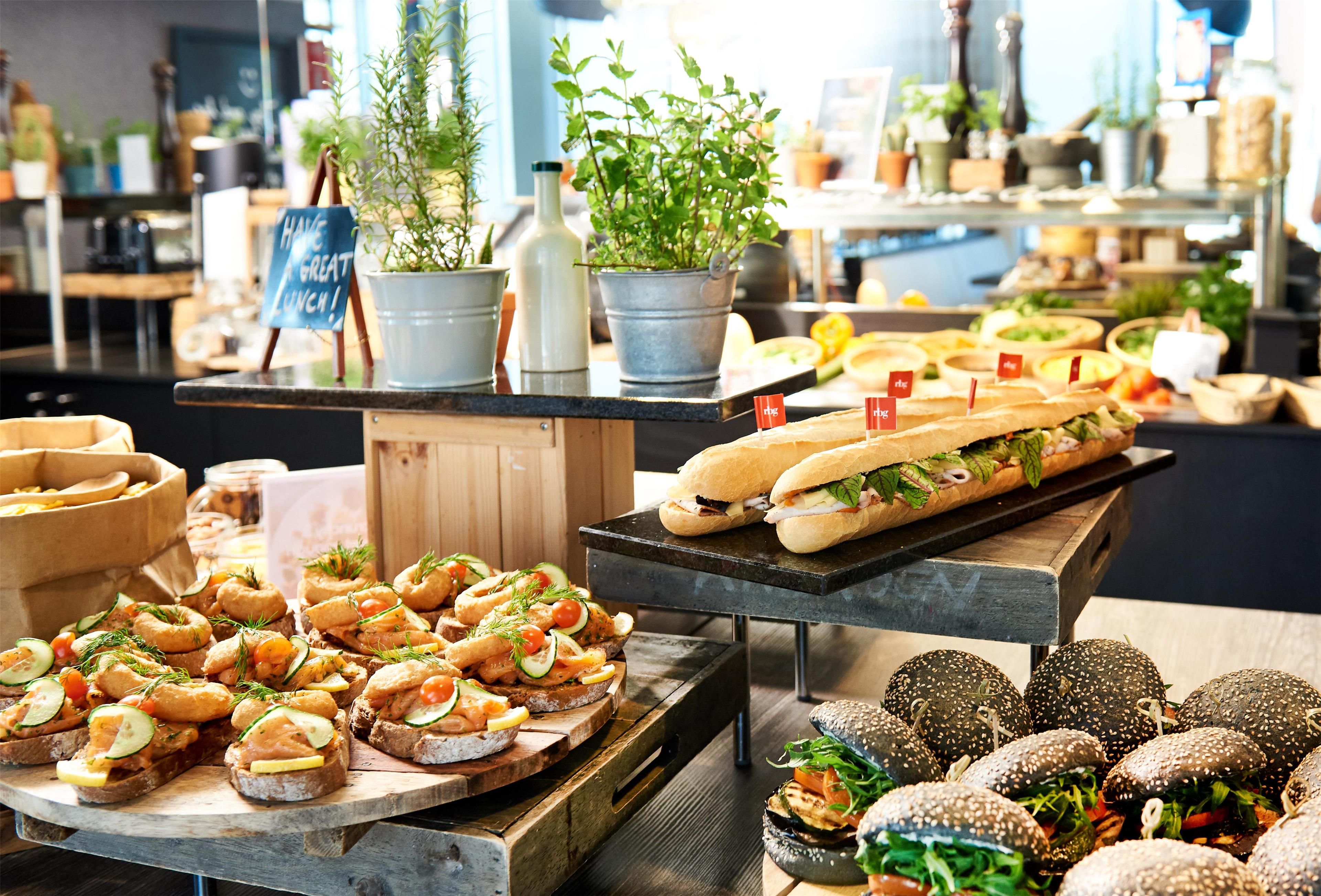 Een buffet met diverse gerechten, waaronder sandwiches, salades en brood.