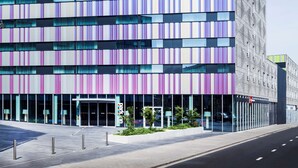Un bâtiment moderne, reconnaissable à son enseigne « Park Inn », qui se distingue par sa façade à rayures et ses grandes fenêtres.