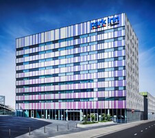 A modern building with a 'park inn' sign, featuring a grid of windows and a flat roof.