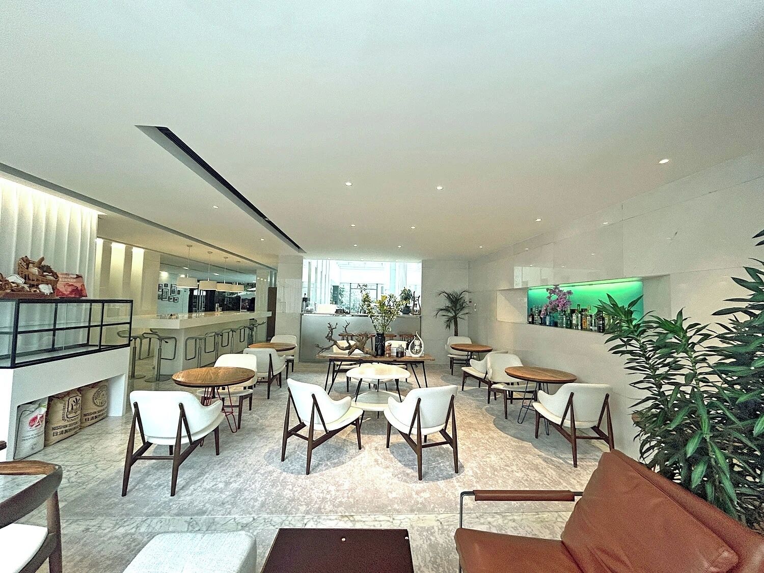A modern interior with a bar area, seating, and a green-lit display.