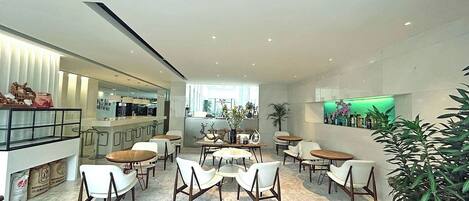A modern interior with a bar area, seating, and a green-lit display.