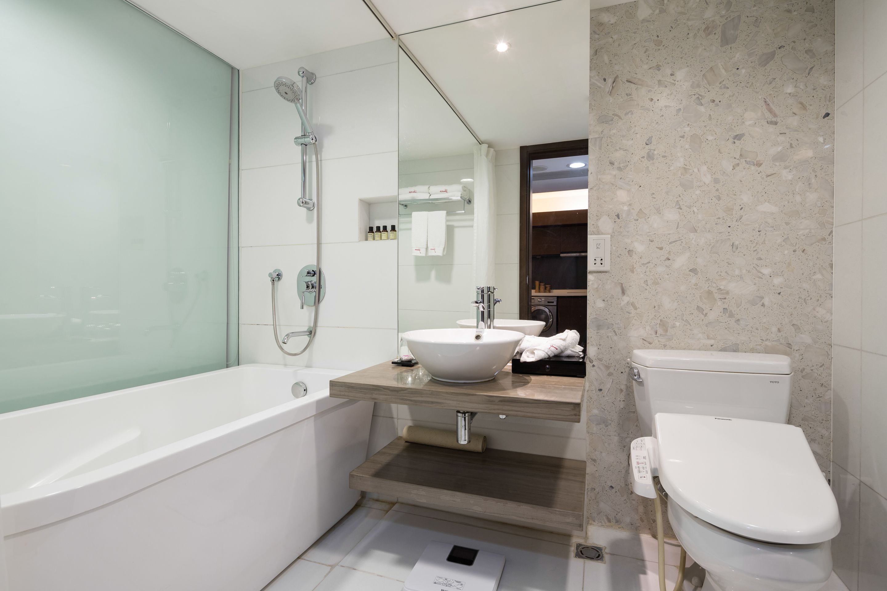 A modern bathroom with a bathtub, a sink, and a toilet.