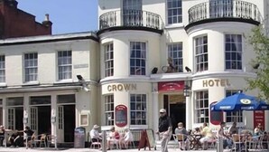 A building with 'Crown Hotel' signage, featuring a corner entrance and a balcony with a railing. - The Crown Hotel (Ryde)