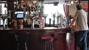 A bar area with a counter, stools, and a variety of bottles and glasses. - The Crown Hotel (Ryde)