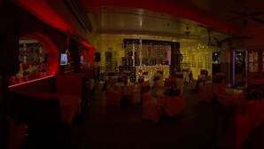 A dimly lit room with tables and chairs arranged for a gathering. - The Crown Hotel (Ryde)