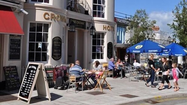 A building with 'Crown' and 'Hotel' signage, outdoor seating, and a signboard. - The Crown Hotel (Ryde)