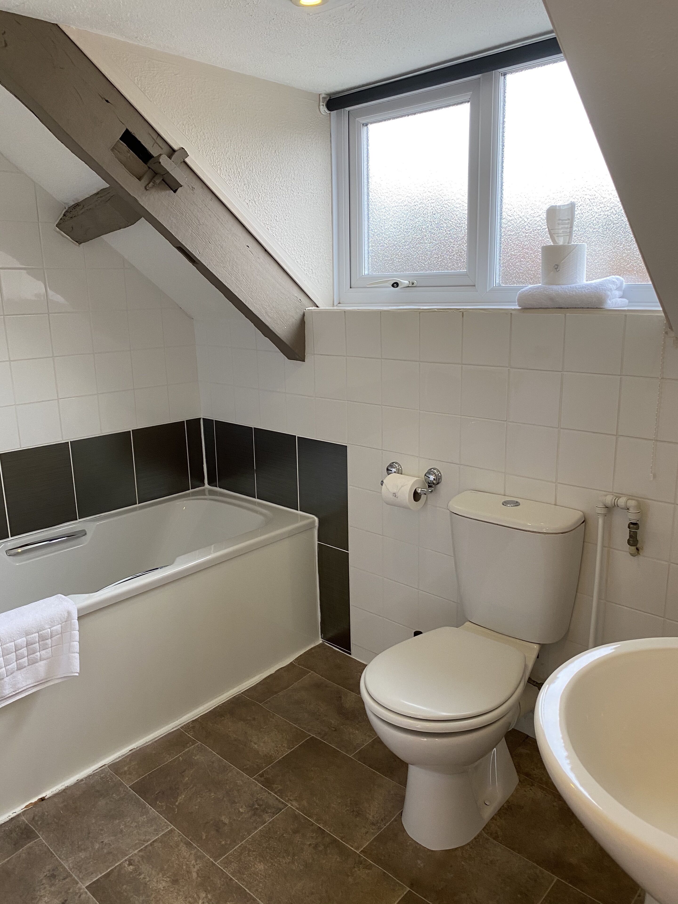 Un baño con bañera, inodoro y lavamanos.