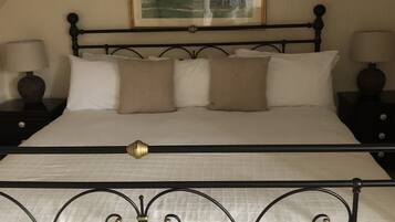 A bed with a metal frame, white bedding, and two bedside tables with lamps.