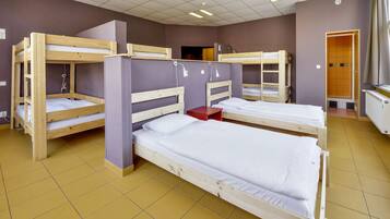 Un dormitorio con literas, un almacenamiento rojo y una puerta que da a otra habitación.