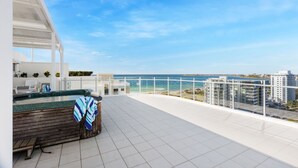 Una terraza en la azotea con vistas al mar y a los edificios.