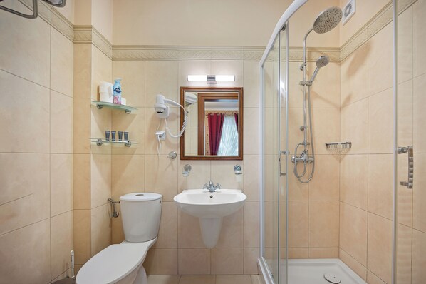A bathroom with a toilet, sink, and shower.