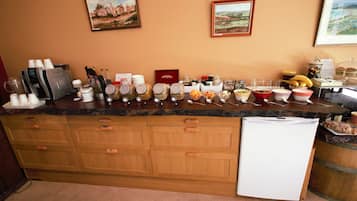 Una encimera de cocina con diferentes alimentos, una máquina de café y un refrigerador.