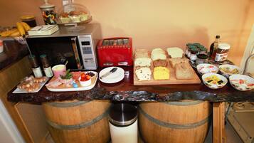 Ein Frühstücksbuffet mit verschiedenen Speisen, einem Toaster und Beilagen.