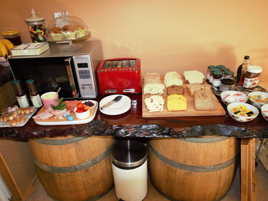 Ein Frühstücksbuffet mit verschiedenen Speisen, einem Toaster und Beilagen.