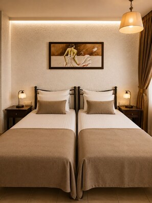 A double room with two beds, a painting on the wall, and bedside lamps. - Villa Danezis (Santorini)