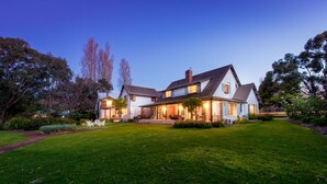 A large, two-story house with a well-maintained lawn and a driveway leading to the entrance. - Sienna Lodge (Yallingup)