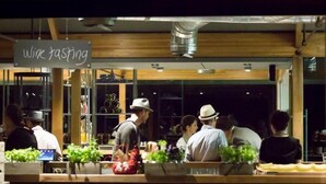 A restaurant with a chalkboard sign reading "wine tasting" and a visible wine rack. - Sienna Lodge (Yallingup)