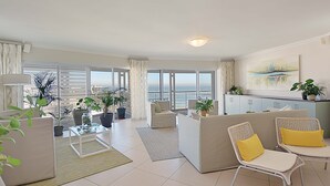Een ruime woonkamer met balkon, modern meubilair en uitzicht op de stad.