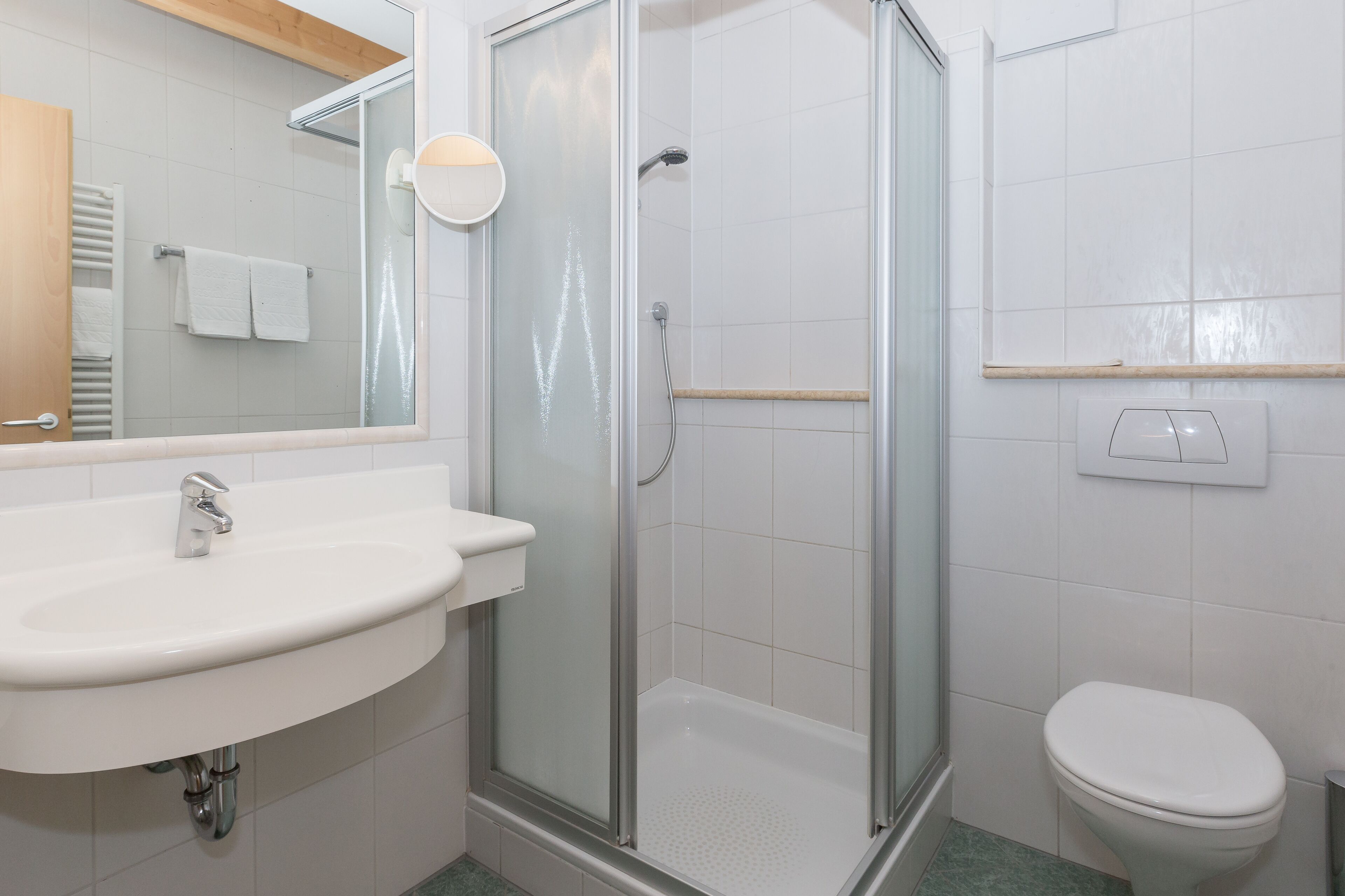 Une salle de bain avec une douche à parois de verre, un lavabo et des toilettes.