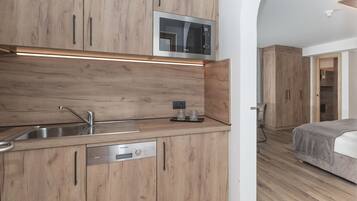 A modern kitchen with wooden cabinets, a built-in microwave, a Siemens dishwasher, and a stainless steel sink.