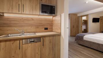 A modern kitchen with wooden cabinetry, a built-in microwave, and a stainless steel dishwasher.
