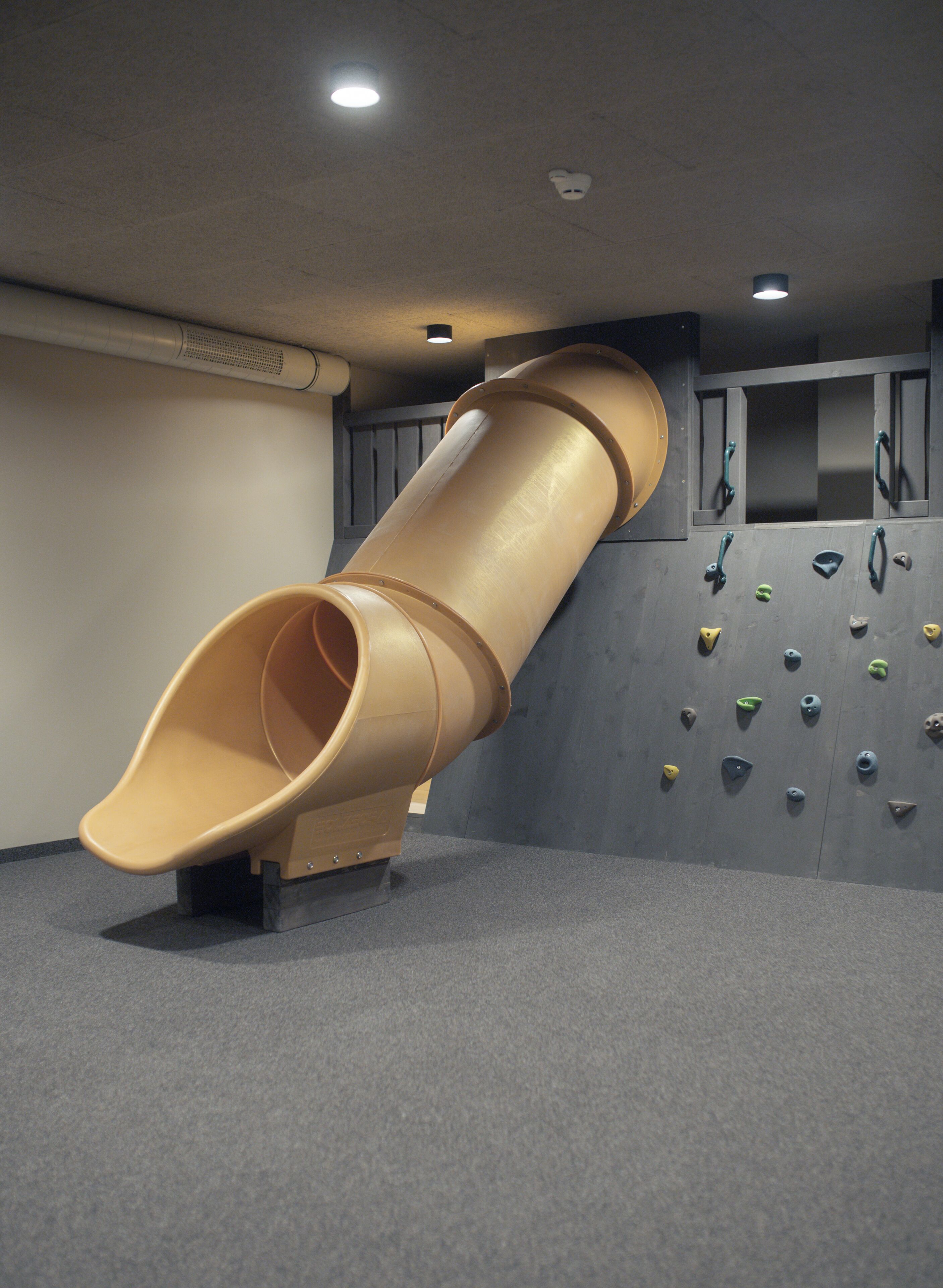 Un área de juegos con un tobogán y una pared de escalar.