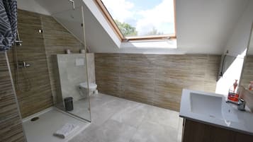Familiekamer | Badkamer | Een douche, een haardroger, handdoeken
