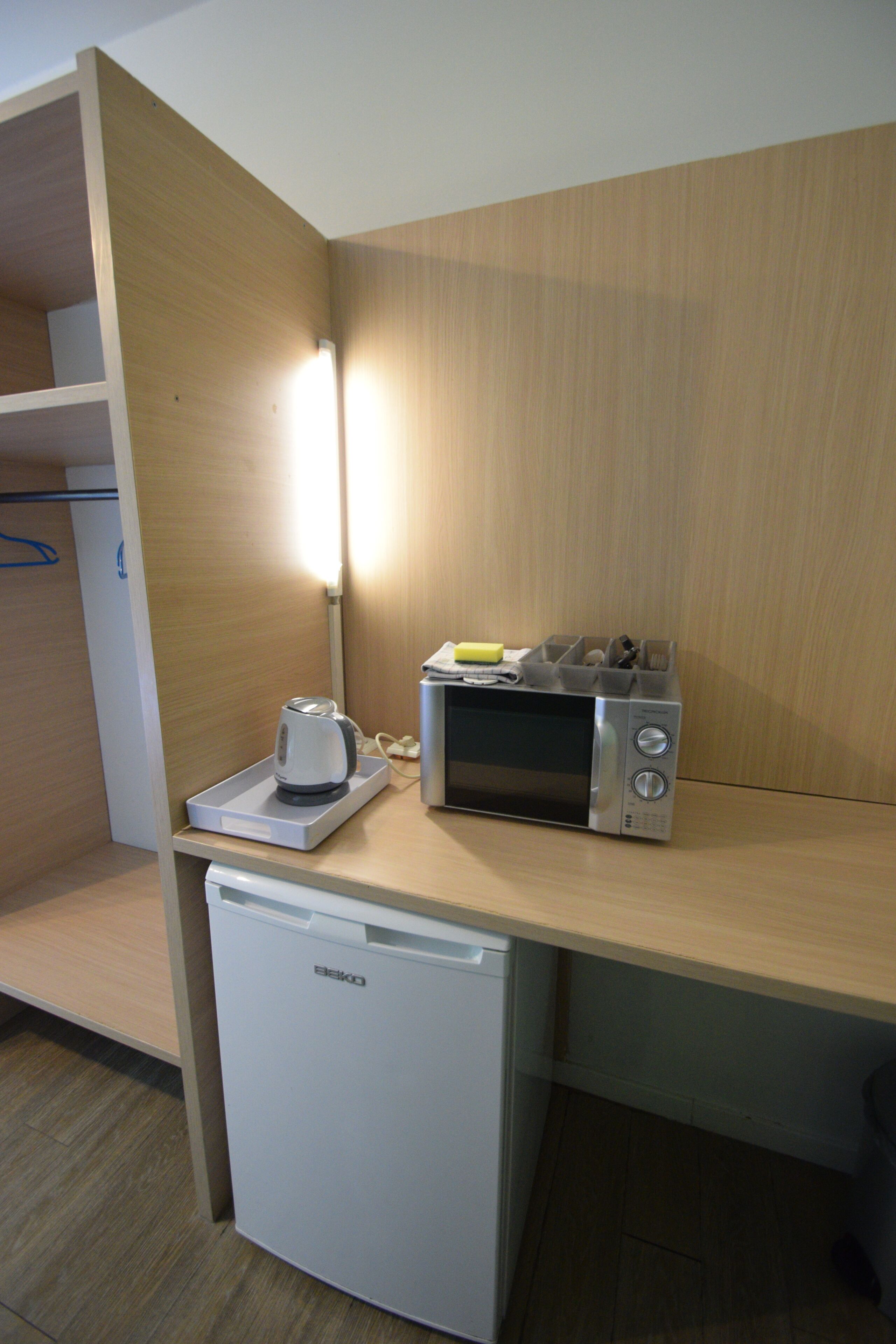 A kitchenette with a microwave, toaster, and a small refrigerator.