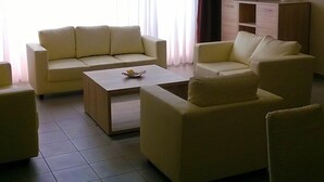 A living room with a sofa set, a coffee table, a TV, and a cabinet. - City Apartments Antwerp (Antwerp)