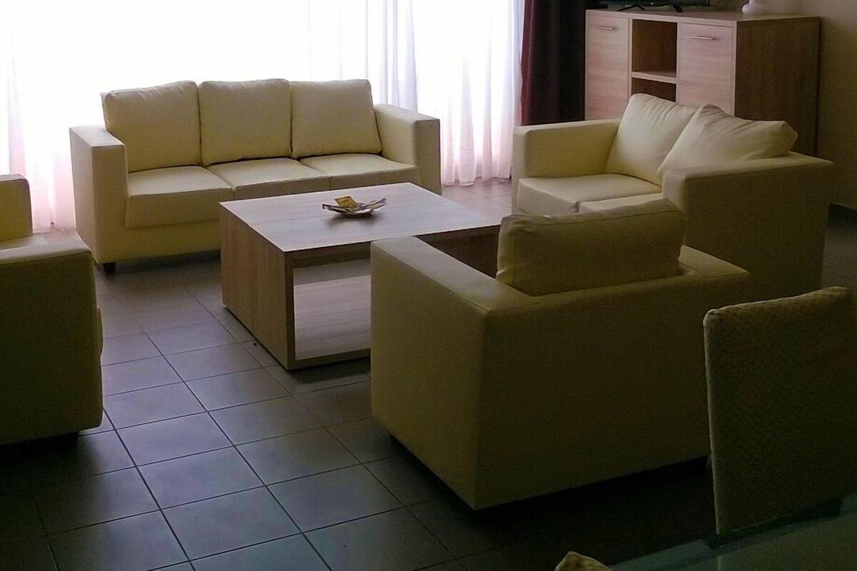 A living room with a sofa set, a coffee table, a TV, and a cabinet.
