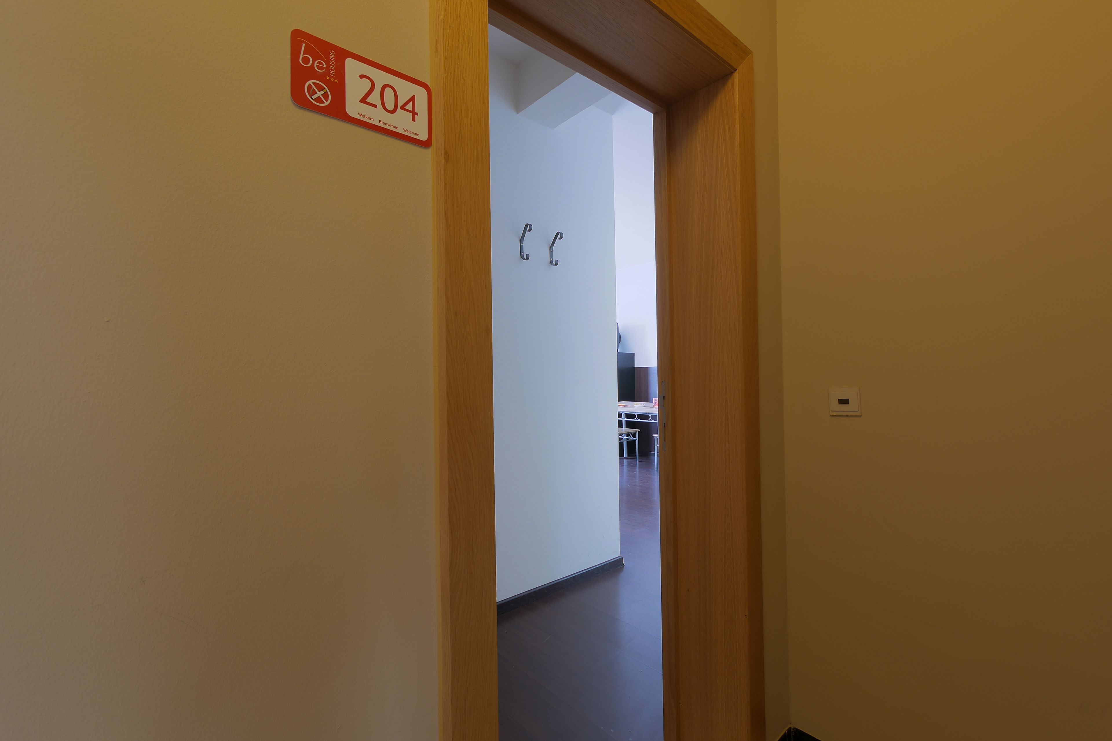 Un corridoio con una porta con l'indicazione '204' e un cartello che recita '204'.