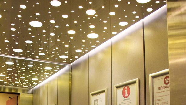 An elevator interior with metallic walls, ceiling lights, and informational signs. - City Apartments Antwerp (Antwerp)