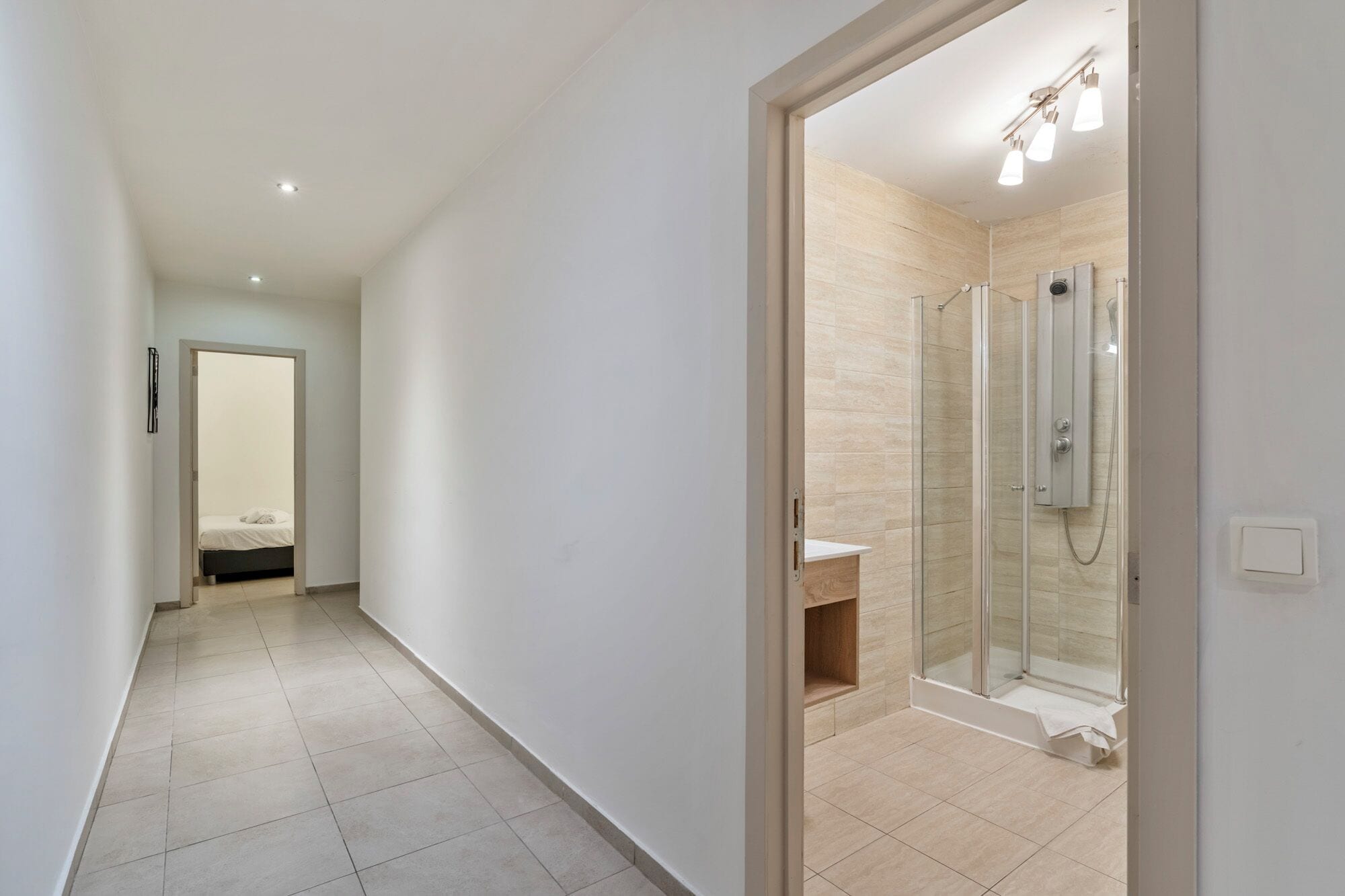 A modern bathroom with a glass shower enclosure, a visible sink, and a toilet.