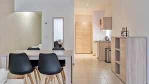 Una cocina moderna con comedor, armarios de madera y una pequeña zona de kitchenette.