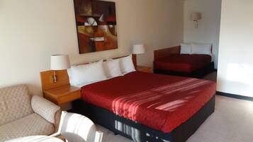 Habitación de hotel con dos camas, un sofá, un escritorio y un cuadro en la pared.