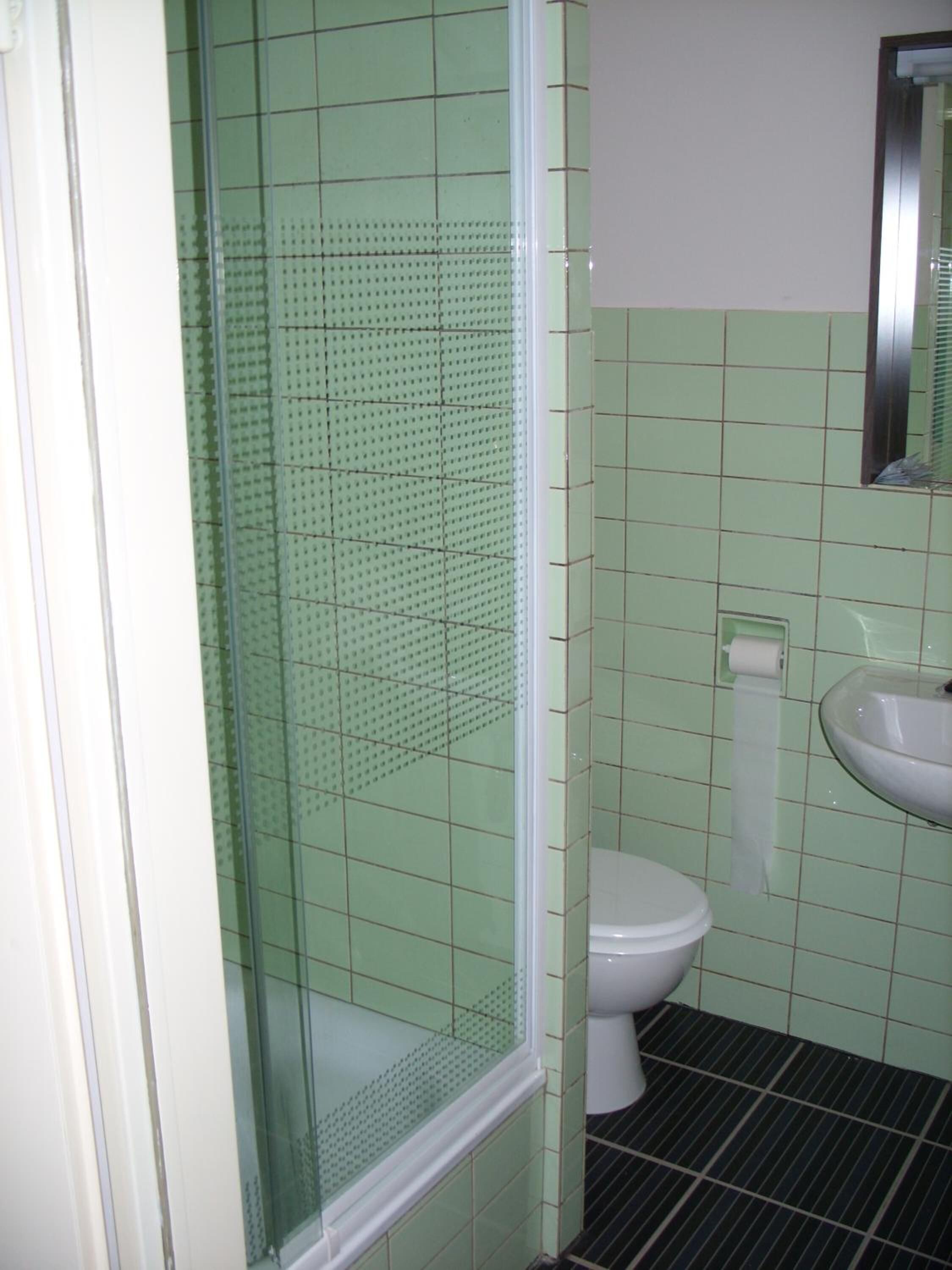 Une salle de bain avec une douche, des toilettes et un lavabo.