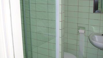 Une salle de bain avec une douche, des toilettes et un lavabo.