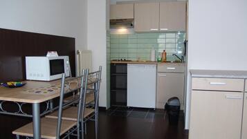A compact kitchen with a microwave, a small refrigerator, and a sink.