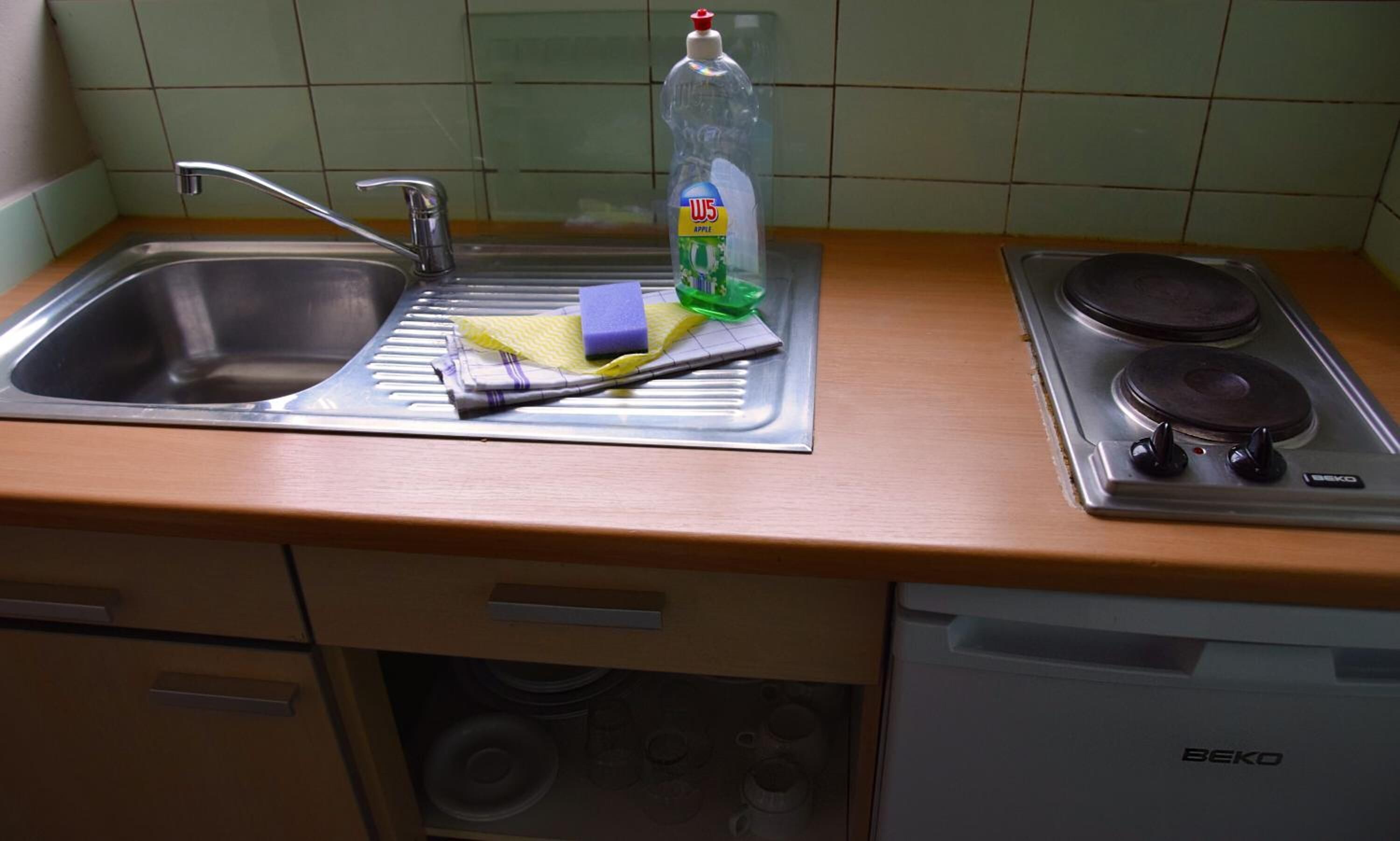 Une cuisine équipée d’un évier, d’une cuisinière et d’un lave-vaisselle.