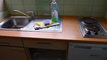 Une cuisine équipée d’un évier, d’une cuisinière et d’un lave-vaisselle.