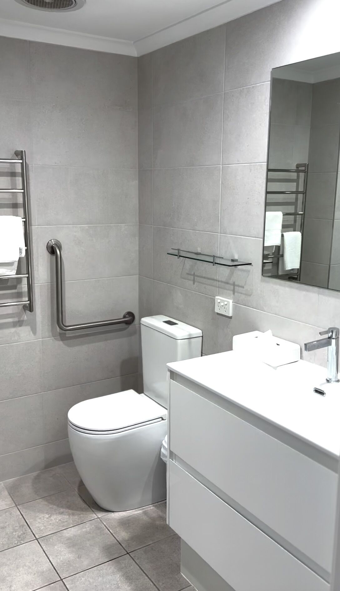 Ein modernes Badezimmer mit Toilette, Bidet und Waschbecken mit Spiegel.