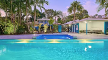 Una piscina al aire libre, sillones reclinables de piscina