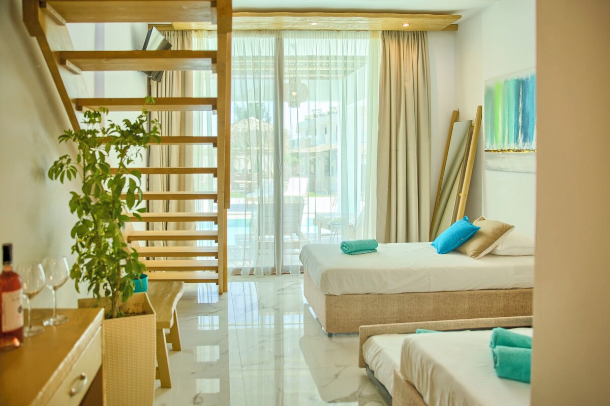 A hotel room with a bed, a desk with a plant, and a window with curtains.