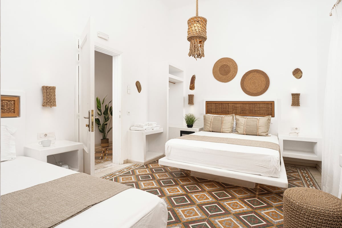 Un dormitorio moderno con una cama colgante, paredes blancas y un suelo estampado.
