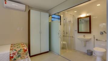 A modern bathroom with a glass shower enclosure, a white sink, and a toilet.